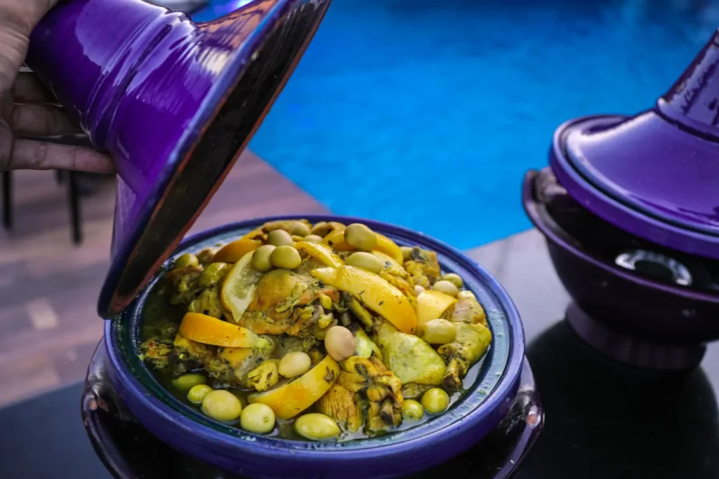 Moroccan tagine with olives and preserved lemon served by the pool