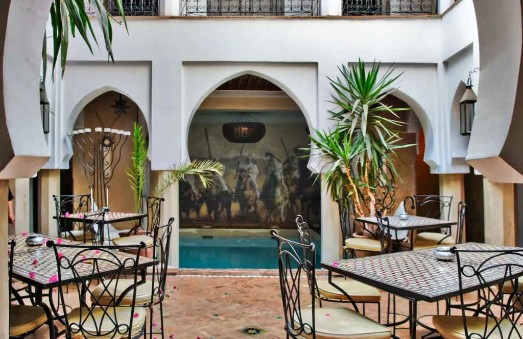 Moroccan riad courtyard with a small pool and dining tables