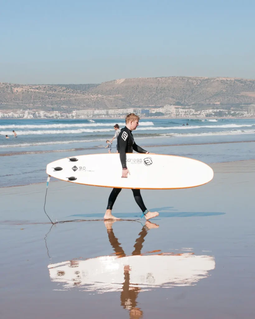 Surfer walking on Agadir beach with his board