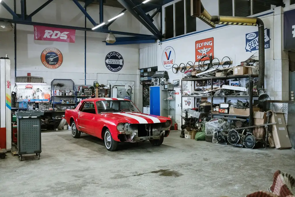 Interior of an auto repair workshop with tools and a car on the floor