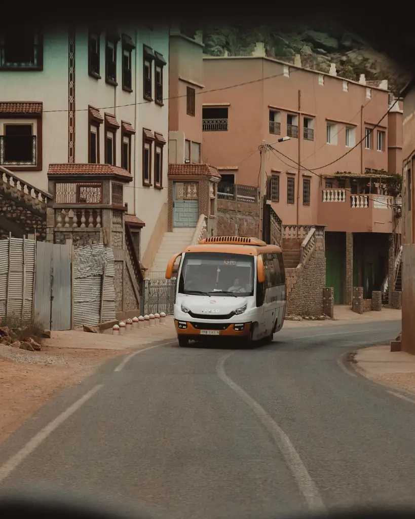 Bus driving along a winding road through a Moroccan town