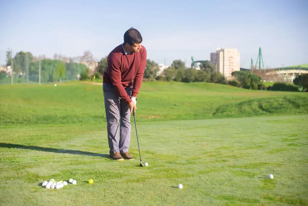 Golfer practising shots on a driving range before a round