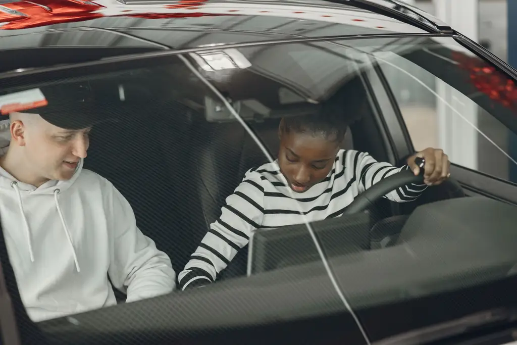 Driving instructor explaining the basics to a learner inside the car