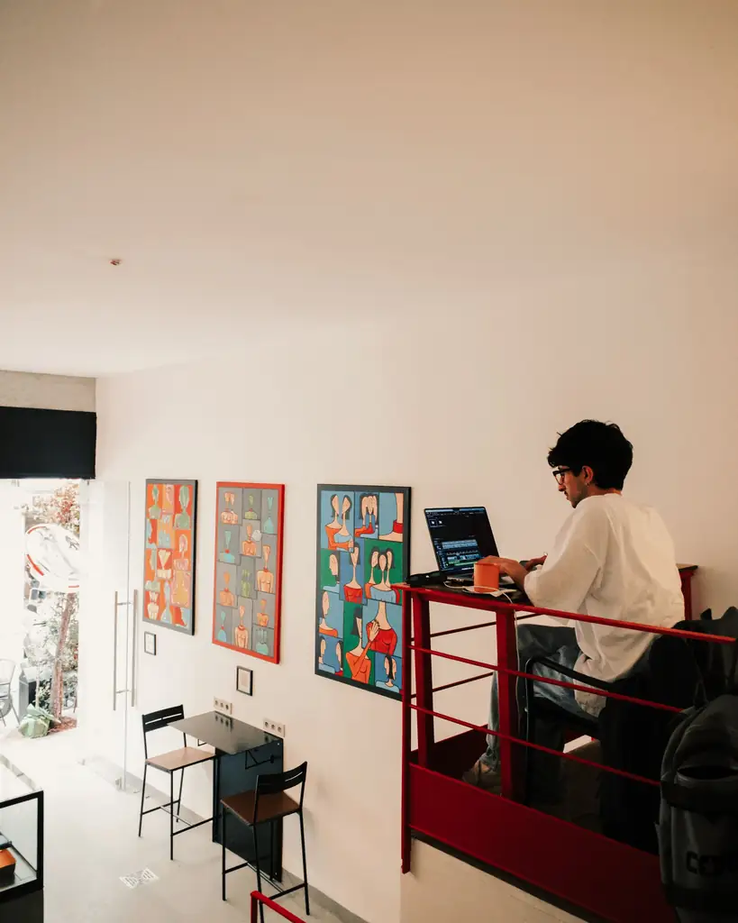 Traveller working on a laptop at a cafe desk, a common way to get online on a trip