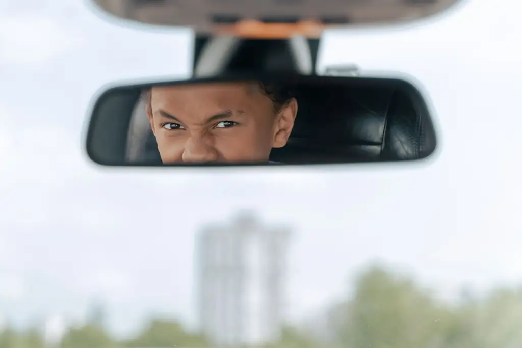 Learner driver checking the rearview mirror, a key habit for the practical exam