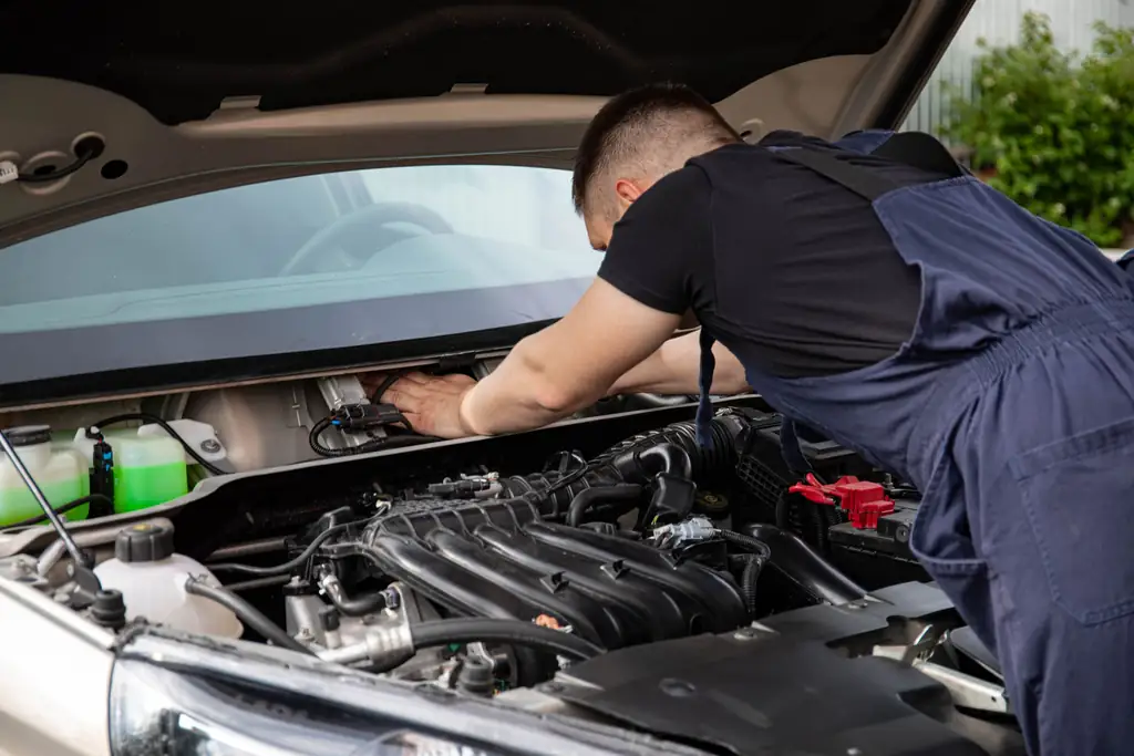 Mechanic servicing a car engine during a routine maintenance check