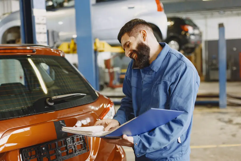 Auto mechanic inspecting a car in a service garage