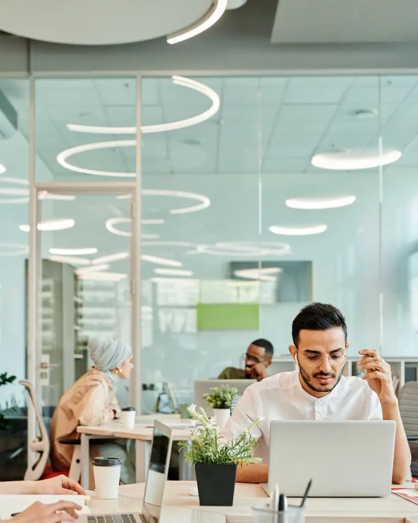 Team working with laptops in a modern open-plan office